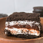 Wooden plate with a serving of chocolate lasagna dessert.