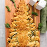 Baked puff pastry filled with spinach dip and shaped like a Christmas tree.
