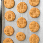 Baked peanut butter cookies on a baking sheet.