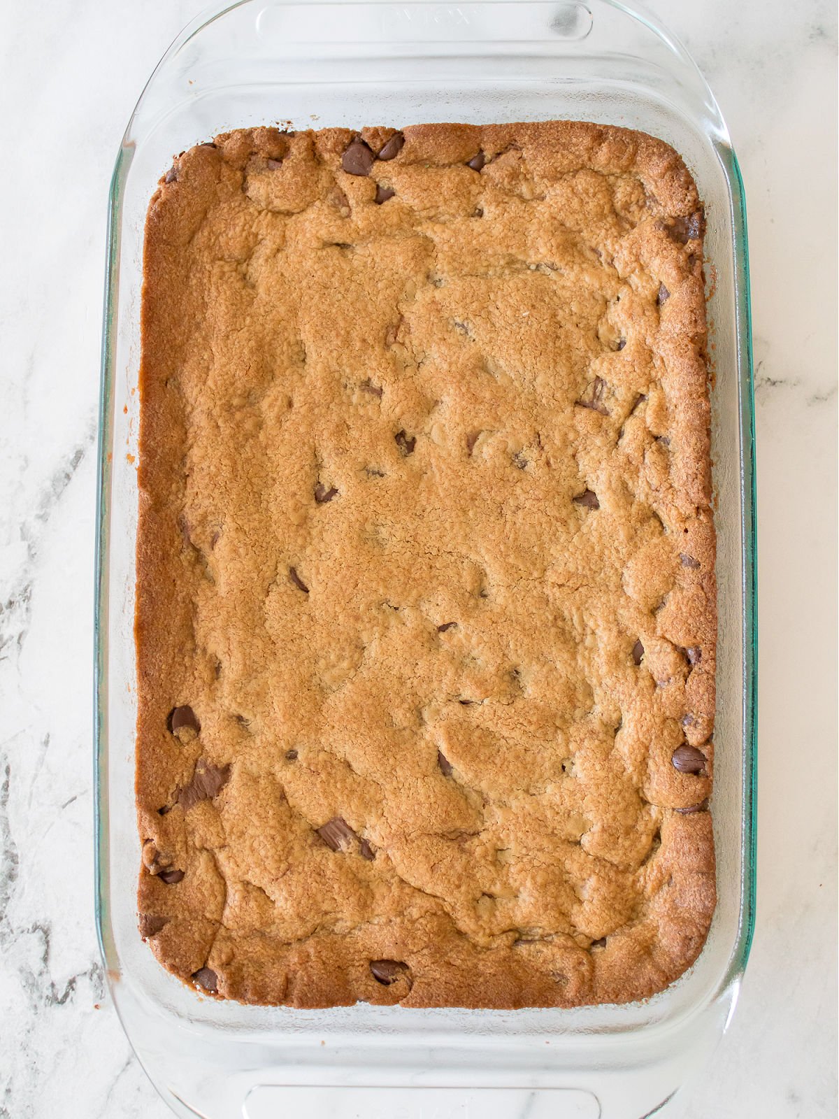 Baked peanut butter blondies in a glass rectangle baking dish.