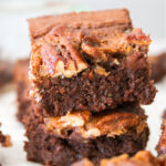 Stack of pecan pie brownies on parchment paper.