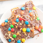 Stack of chocolate pretzel bark on a small white plate.