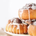 Stack of freshly baked cinnamon rolls with cream cheese icing.