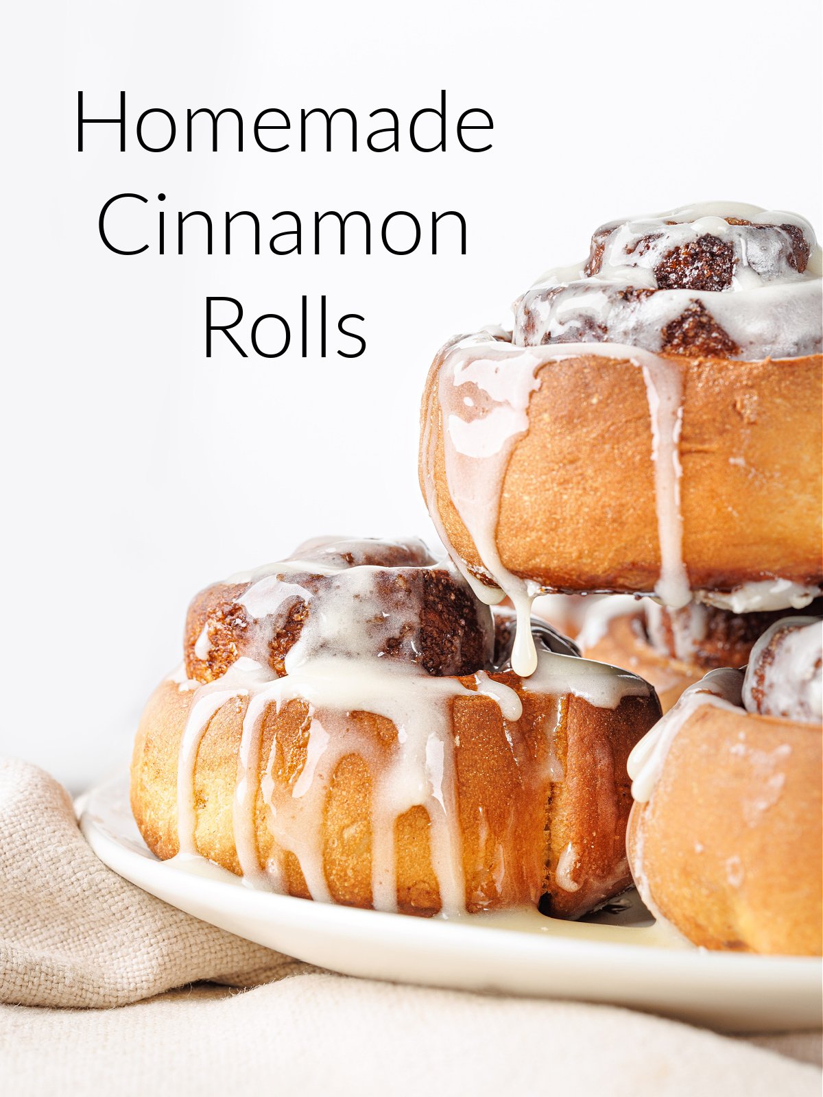A plate of cinnamon rolls with cream cheese icing dripping down the side.