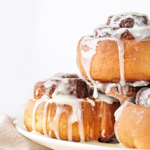 Stack of freshly baked cinnamon rolls with cream cheese icing.