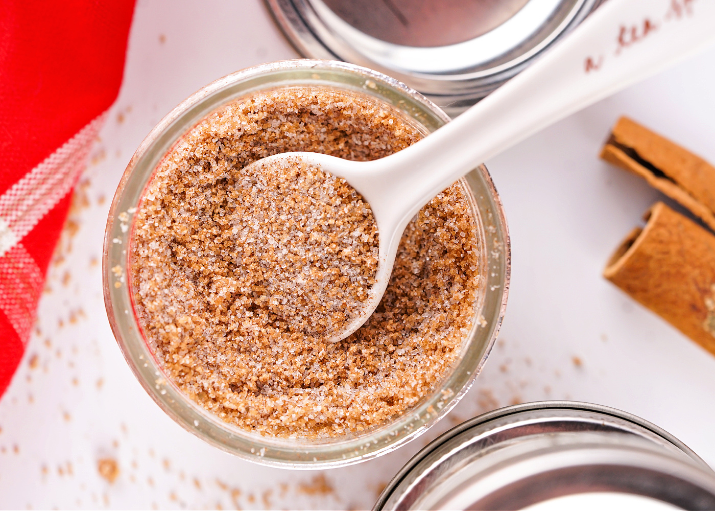 White spoon in a jar getting a scoop of apple cider mix.