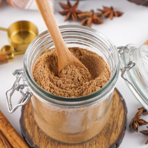 Wooden spoon in a jar of chai spice mix.