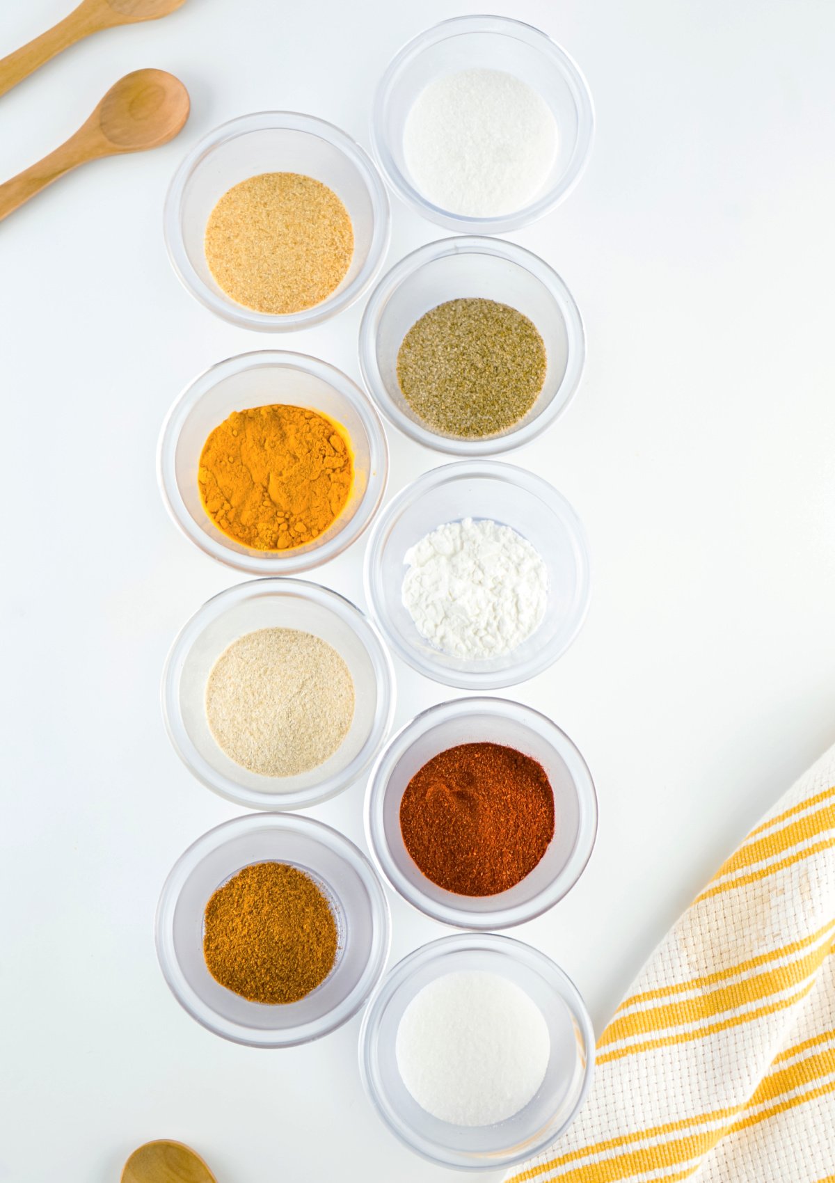 Nine small bowls filled with different spices.