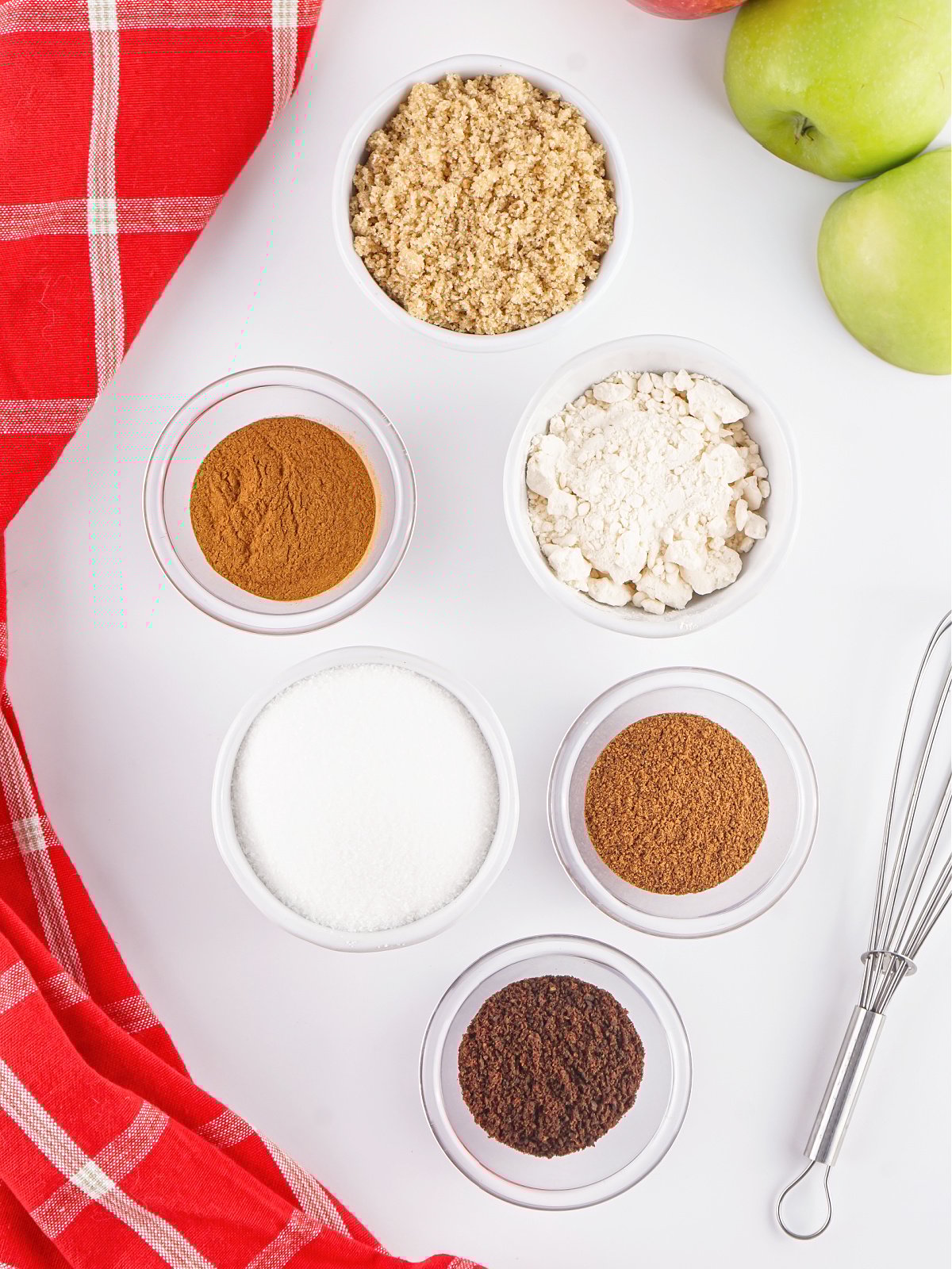 Six small jars filled with spices, sugar, and powdered apple.