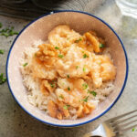 Bowl of honey walnut shrimp on top of a bed of rice.