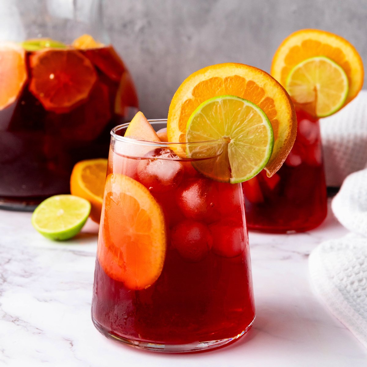 Glasses of Sangria garnished with orange and lime slices.