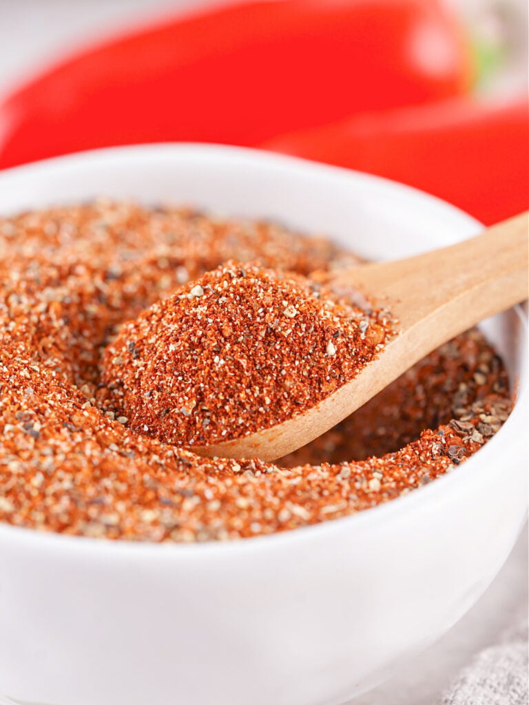 Close-up of a wooden spoon filled with freshly mixed BBQ rub.