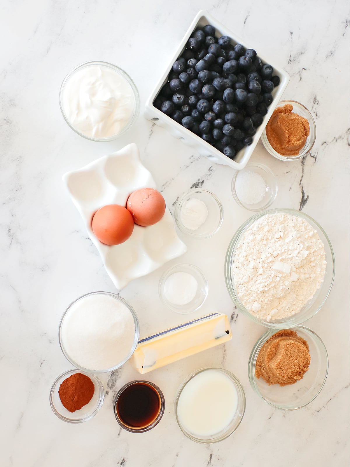 Ingredients laid out on a counter to make blueberry muffins.