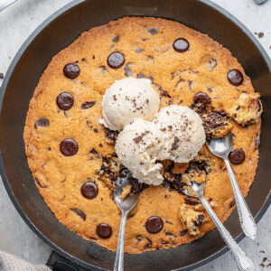 Vanilla ice cream on top of a chocolate chip skillet cookie.