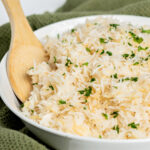 Wooden spoon in a bowl of garlic rice.
