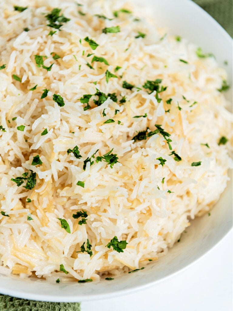 Bowl of garlic rice garnished with cilantro.