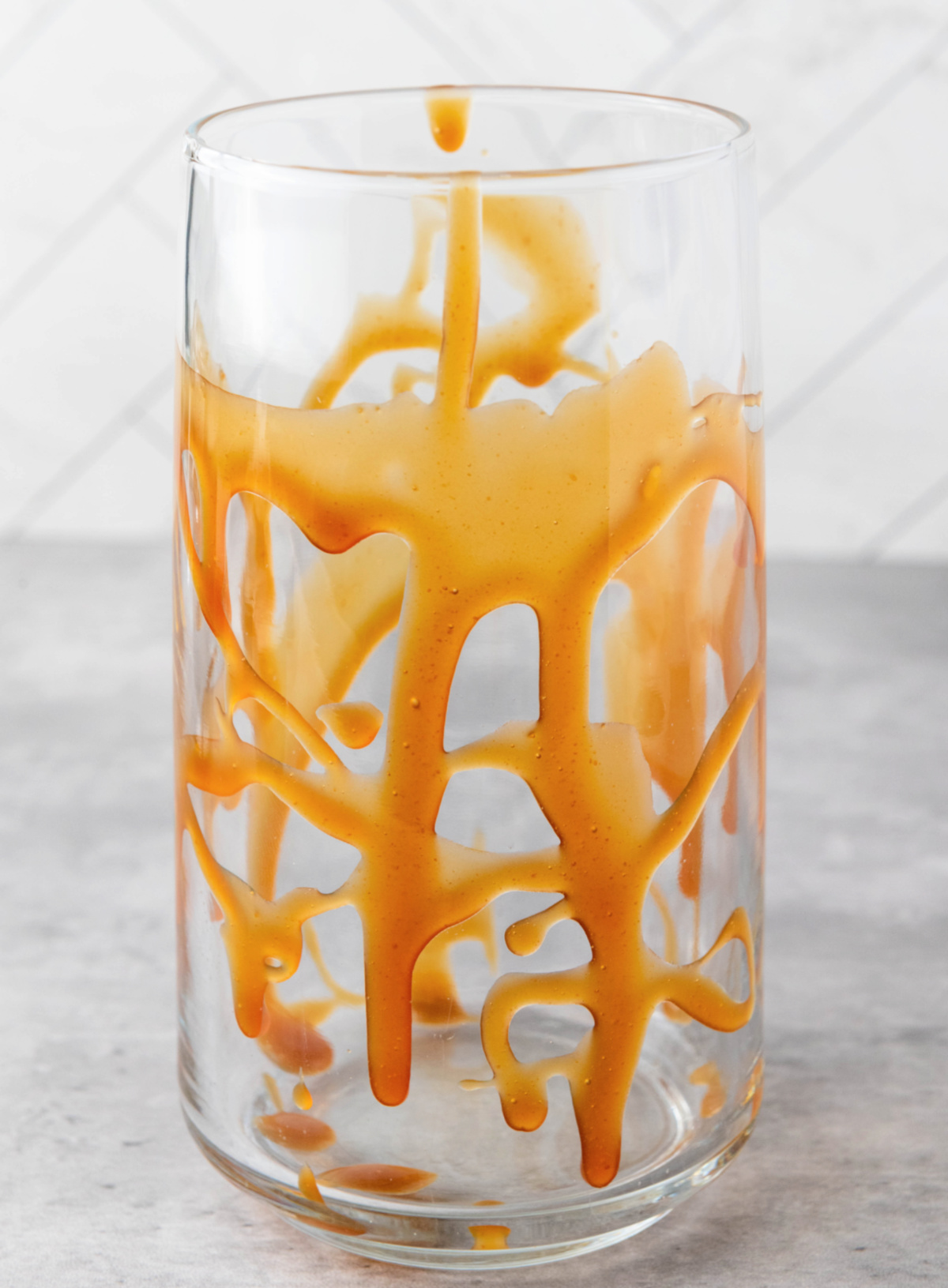 Glass jar coated inside with rich caramel sauce, ready for making iced caramel coffee.