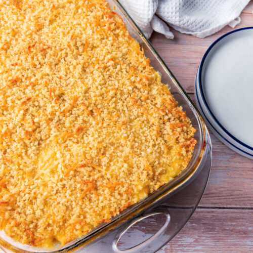 Creamy, cheesy macaroni and cheese casserole in a glass baking dish.