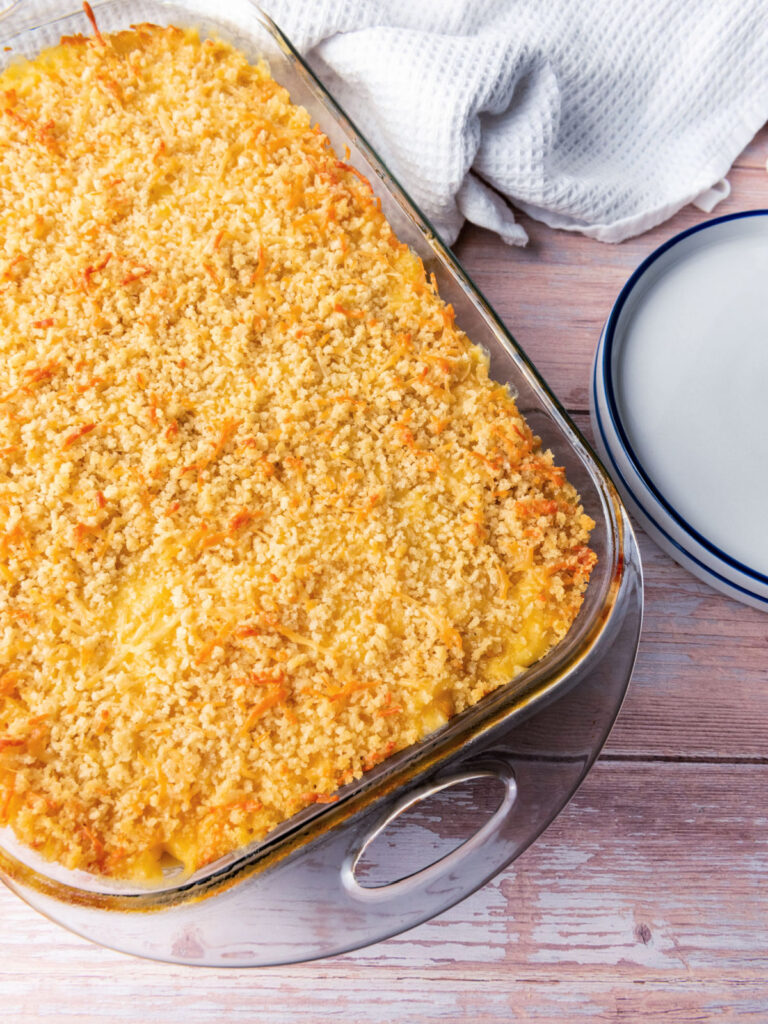 Creamy, cheesy macaroni and cheese casserole in a glass baking dish.