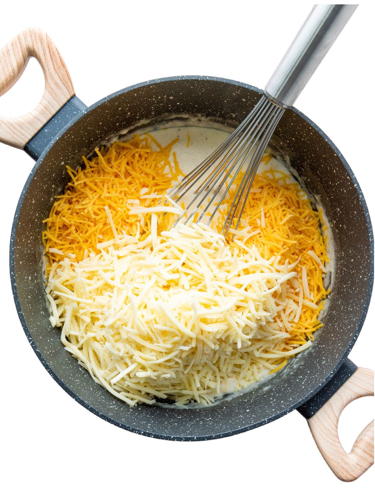 Cheese and cream in a pot being whisked together.