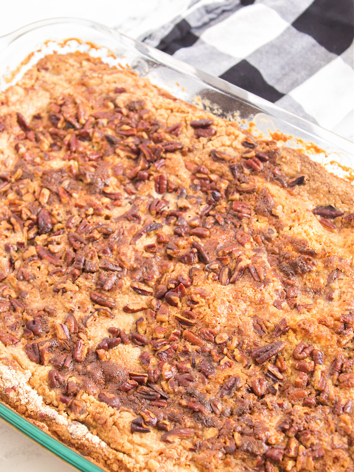 Close-up of a freshly baked Pumpkin Crunch Cake showing its golden crumb topping with toasted pecans.
