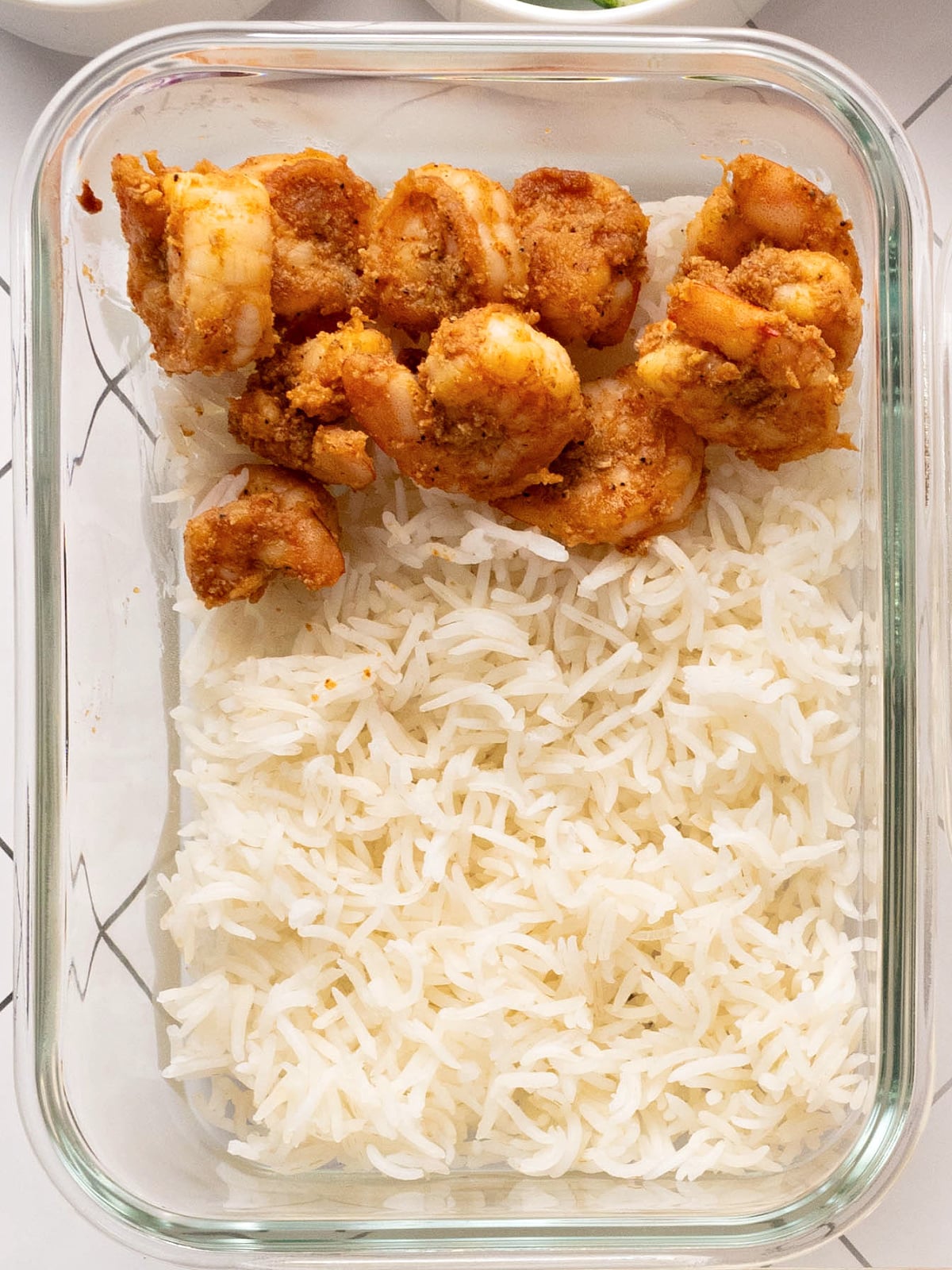 Seasoned, cooked shrimp on a bed of rice.