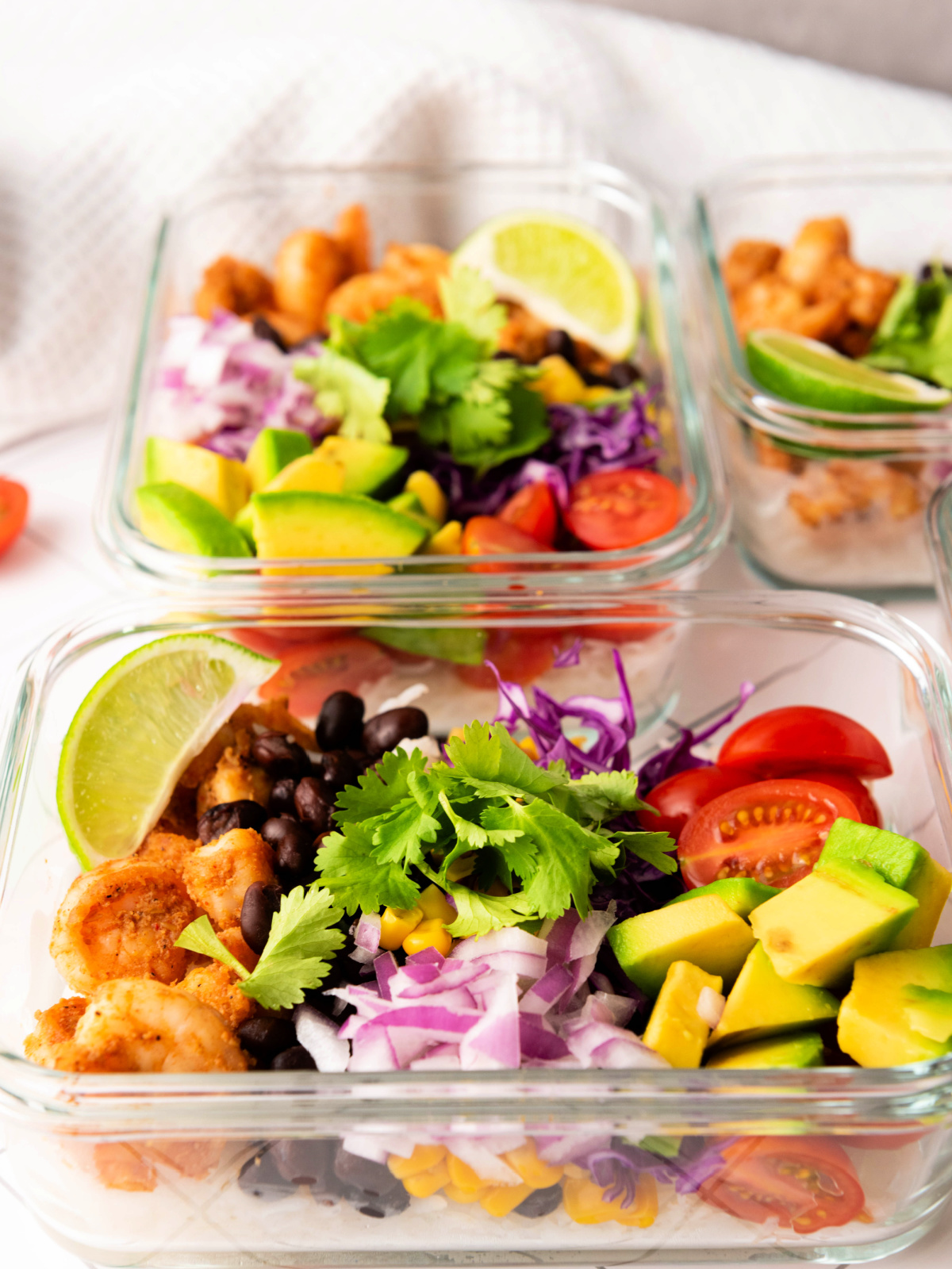 Shrimp and veggies in glass bowls.