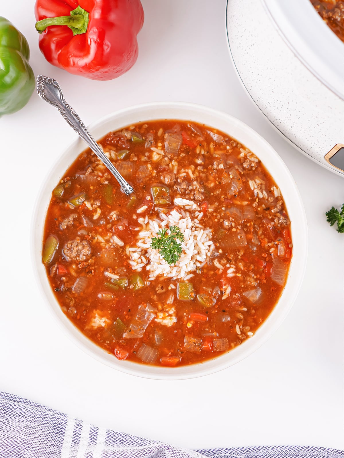 Close-up of Unstuffed Pepper Soup with a spoon dipped into the rich tomato broth, showing chunks of peppers and beef.
