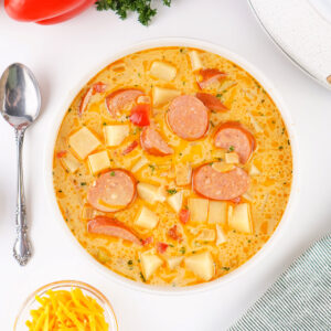 Overhead view of Cajun Potato Soup in a bowl with a spoon placed beside it.