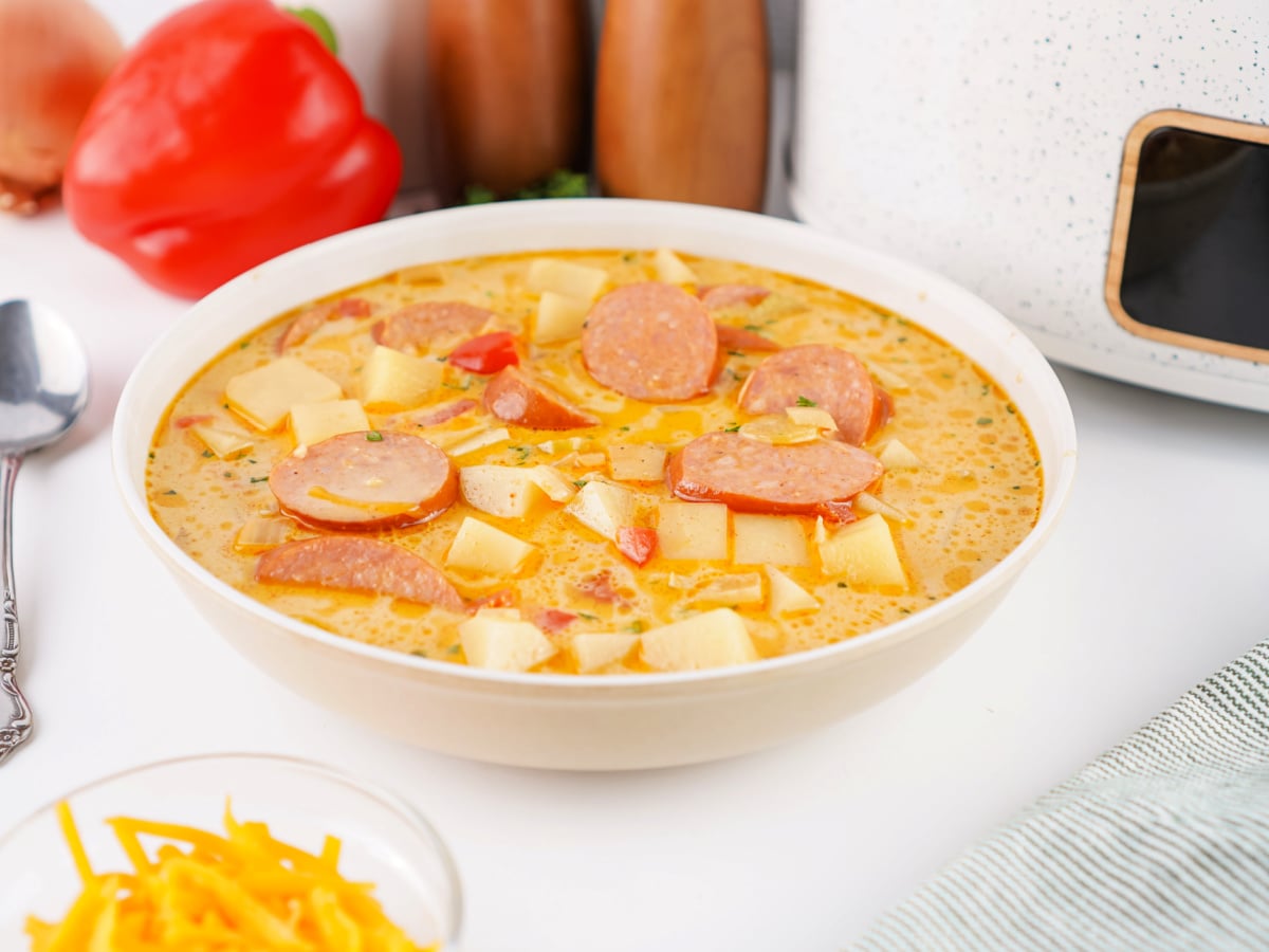 Side view of a bowl of Cajun Potato Soup topped with sausage slices.