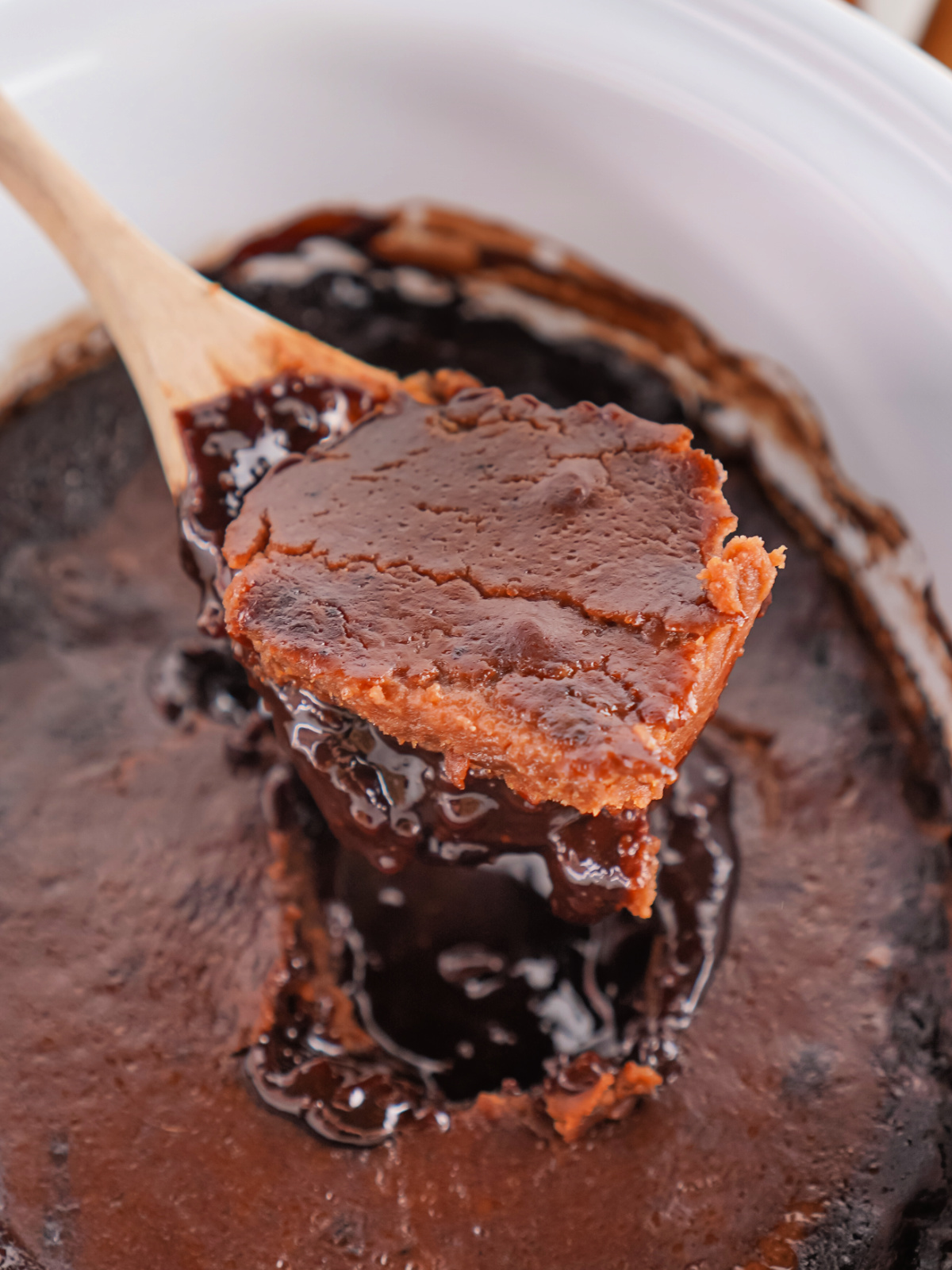 Close-up of gooey chocolate cobbler with a cracked, brownie-like crust.