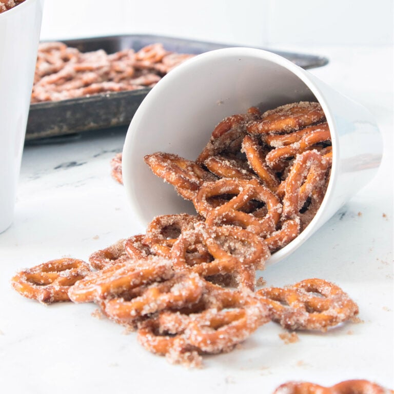 Cinnamon sugar pretzels spilling out of a white bowl onto the counter.