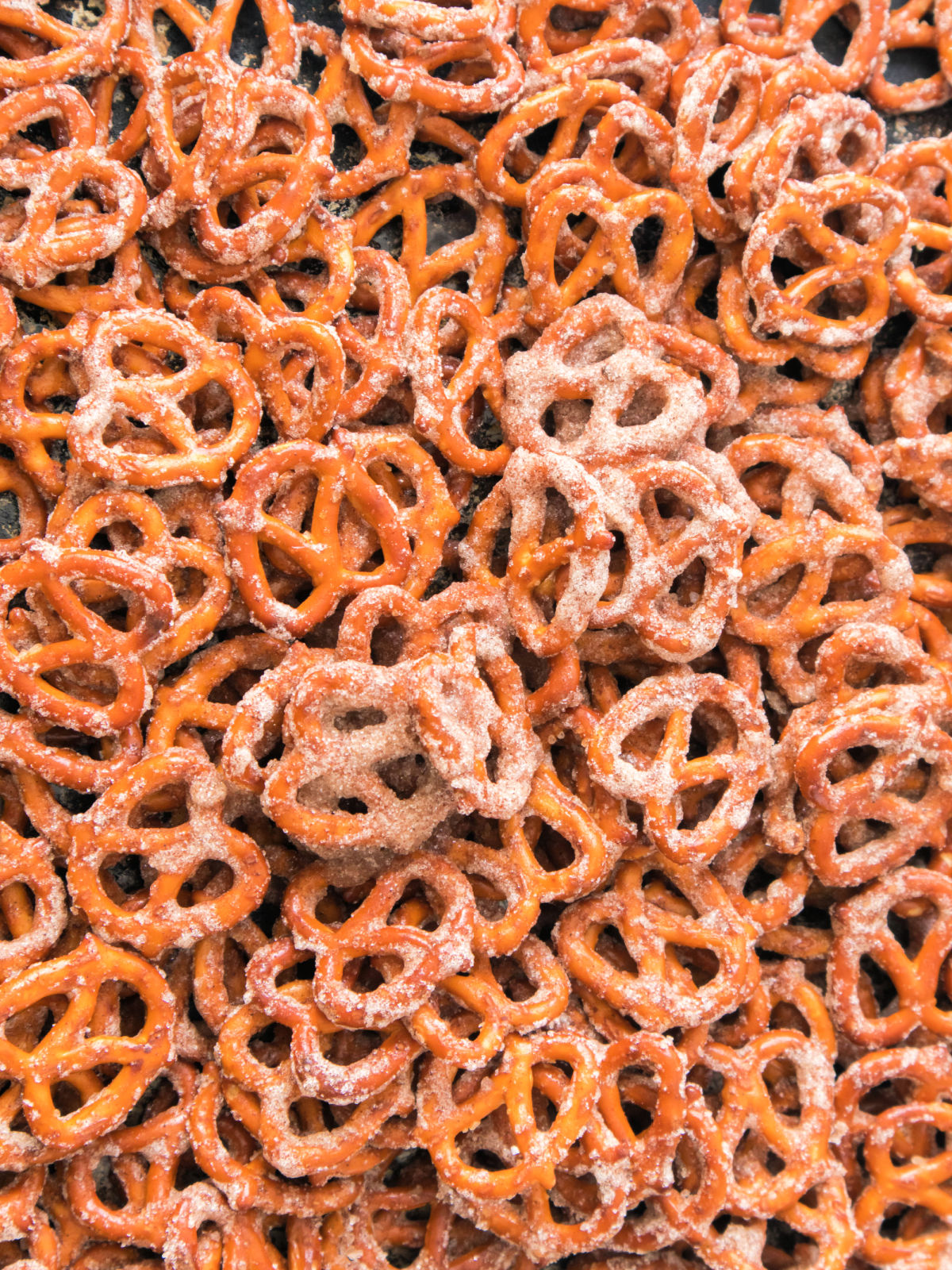 Freshly baked cinnamon sugar pretzels cooling on a sheet pan.