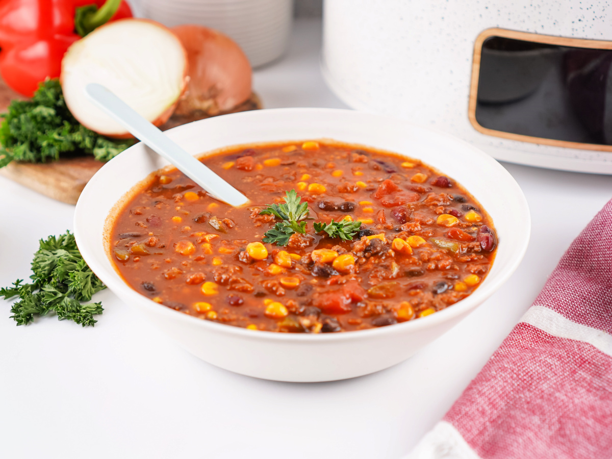 Side view of a bowl of Cowboy Soup with beans, corn, and peppers in a rich broth.
