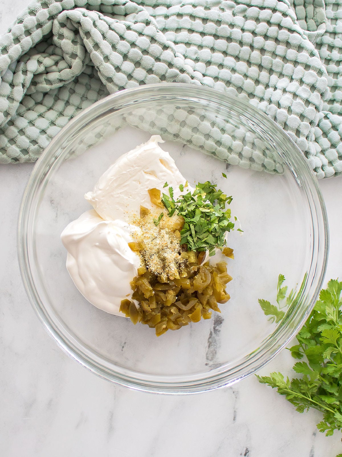 Dip ingredients combined in a glass bowl before being stirred together.