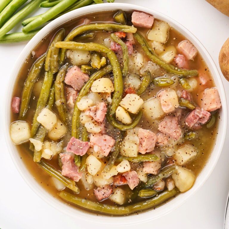 A bowl of ham, green beans, and potatoes, highlighting the rustic Southern comfort meal.