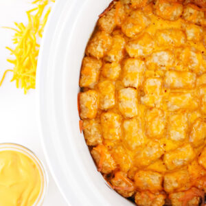 Crockpot taco tater tot casserole with melted cheese and seasoned ground beef.