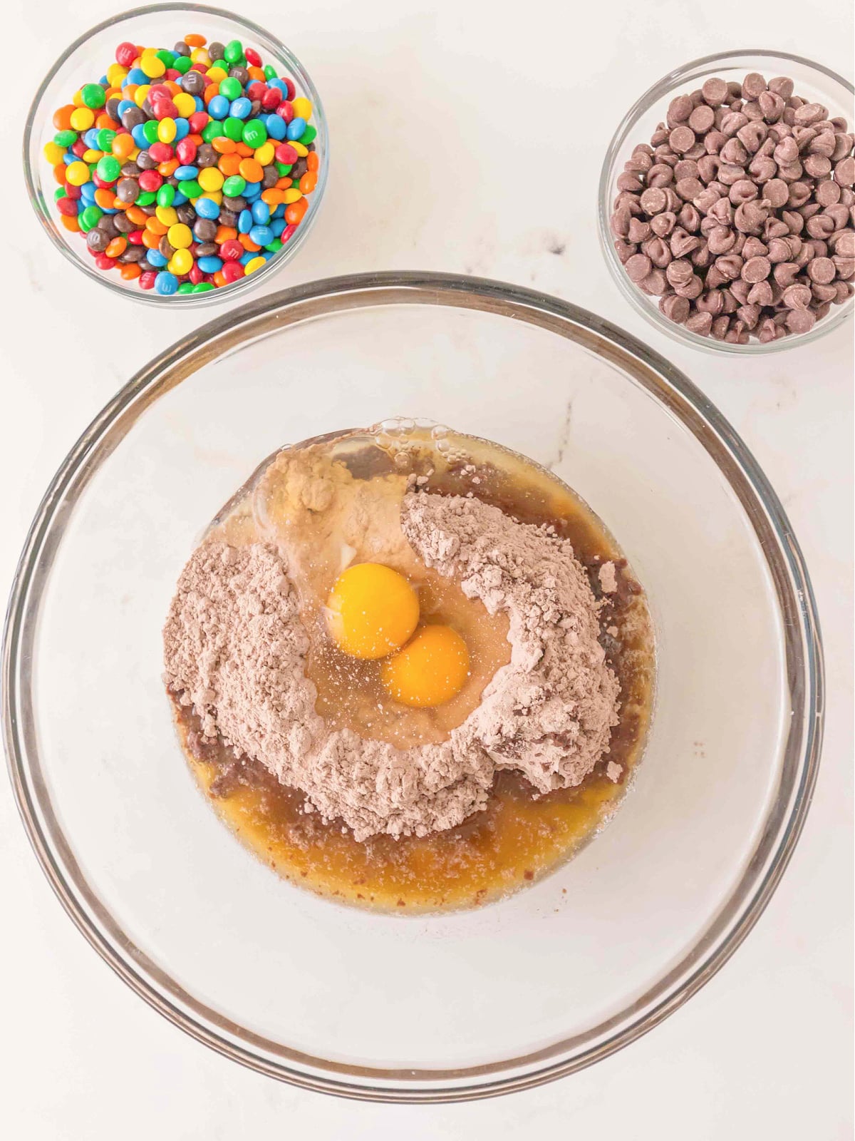 Brownie mix, eggs, and melted butter combined in a glass mixing bowl before stirring.