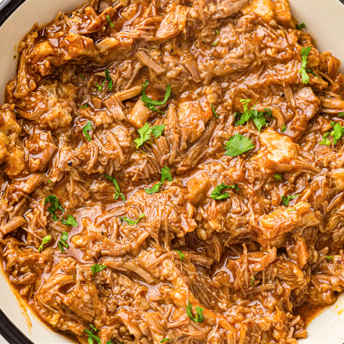 Close-up of saucy instant pot pulled pork with tender shredded texture.
