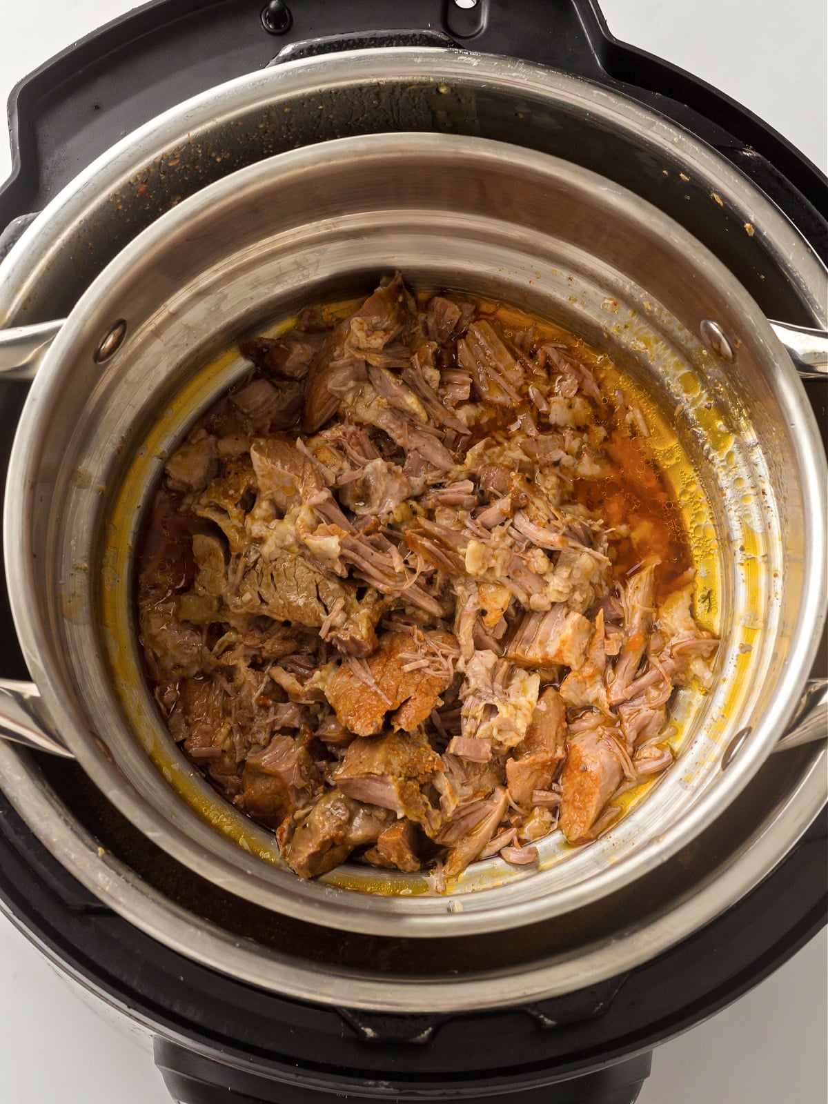 Shredded pork inside the instant pot after cooking.