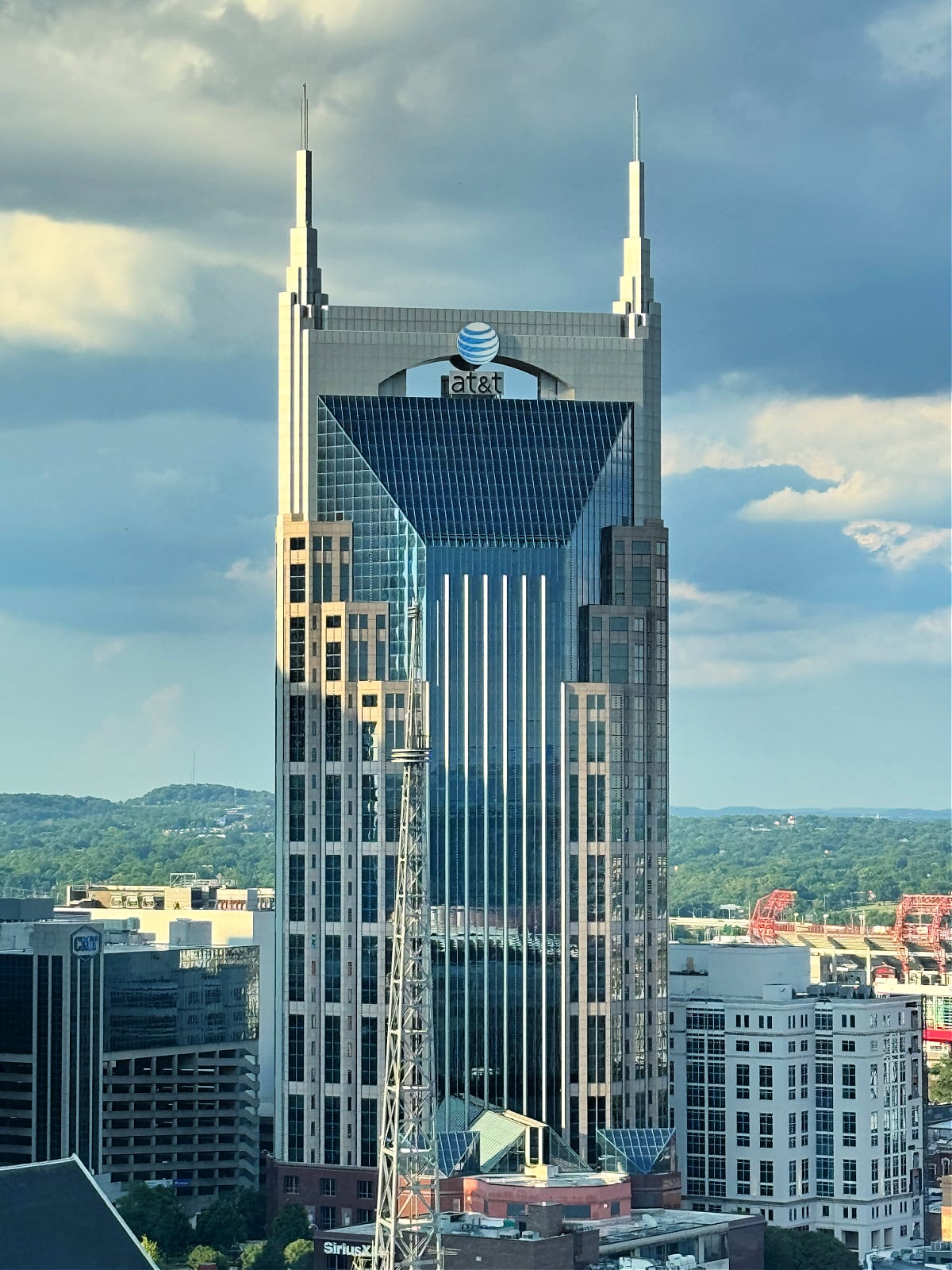 AT&T “Batman Building” skyscraper rising above the Nashville skyline under dramatic clouds.