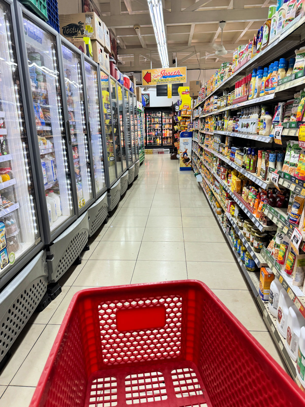 Grocery store aisle inside Super Joseth in Costa Rica with refrigerated cases and stocked shelves.