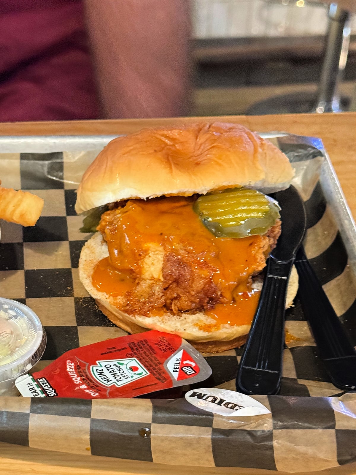 Crispy Nashville hot chicken sandwich topped with pickles and spicy sauce served on a soft bun.