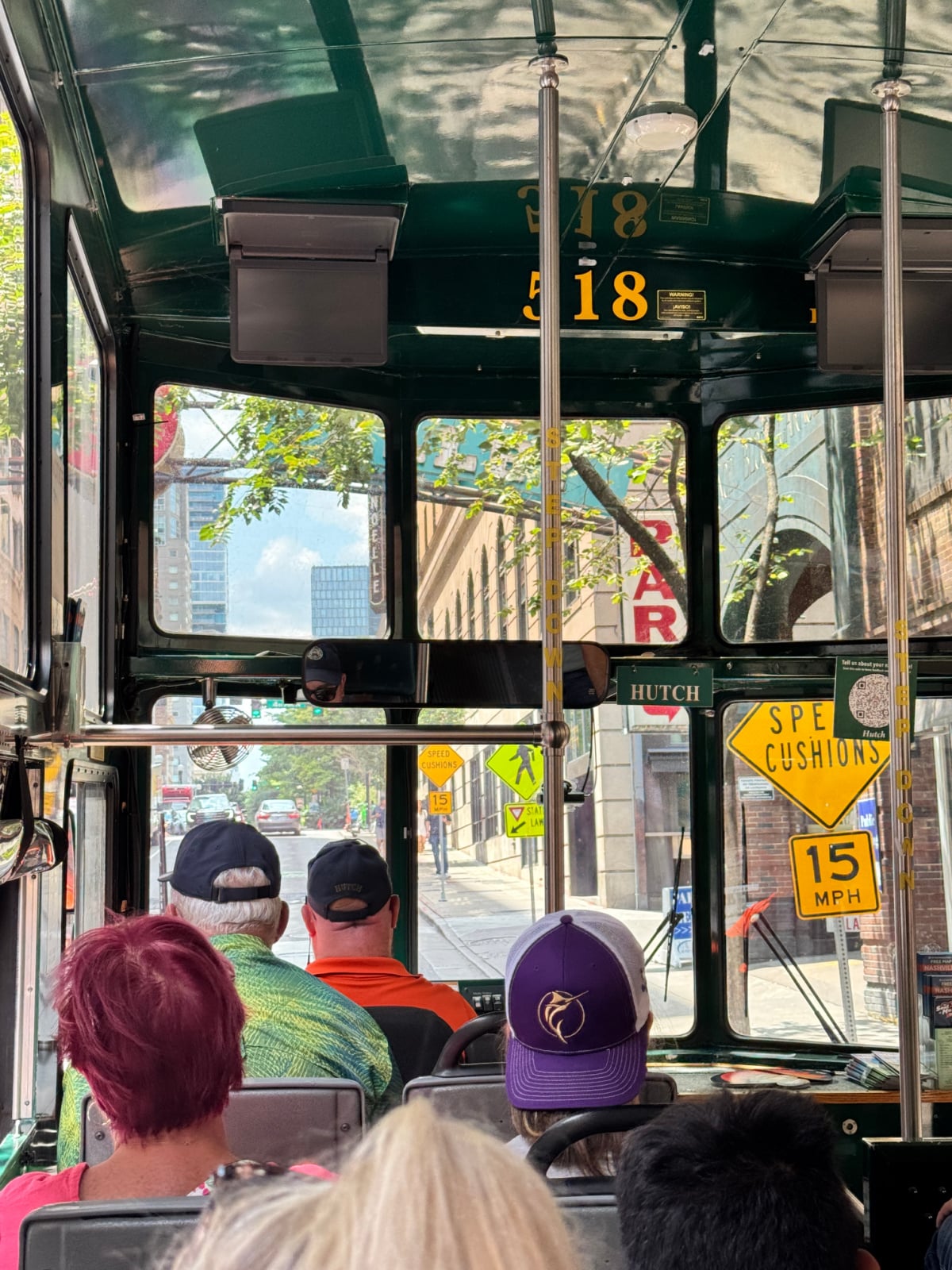 Interior view from an Old Town Trolley tour bus driving through downtown Nashville streets.