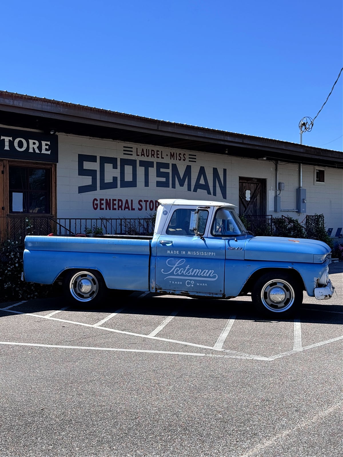 Vintage blue pickup truck parked outside Scotsman General Store in Laurel, Mississippi.