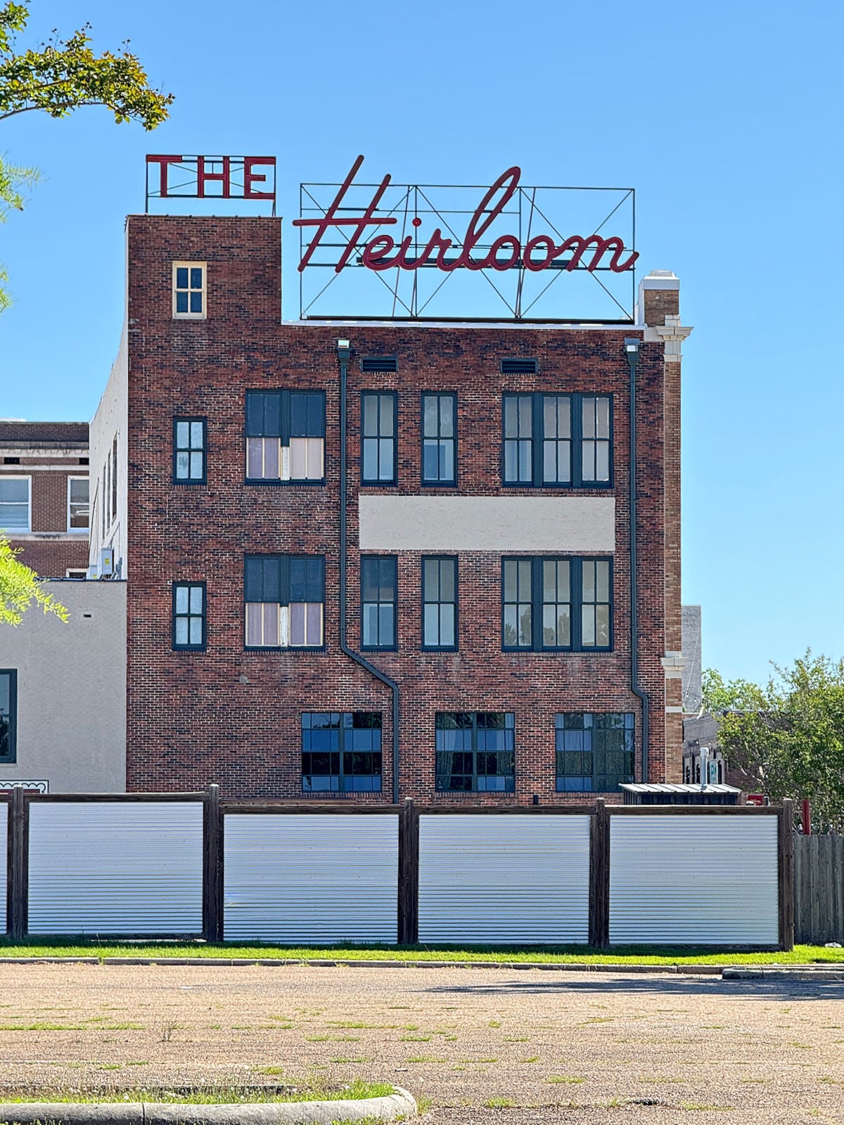Brick building with rooftop “The Heirloom” sign overlooking downtown Laurel.