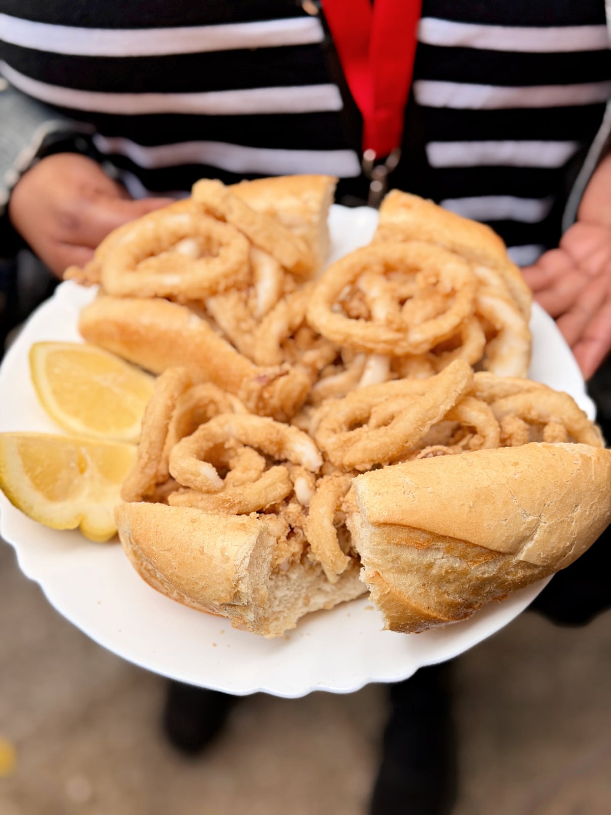 Fried calamari sandwich served on crusty bread with fresh lemon wedges in Madrid.
