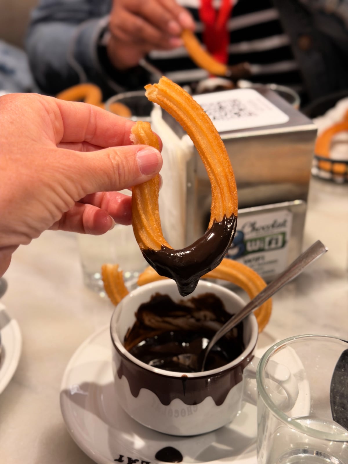 Fresh churro dipped into thick Spanish hot chocolate at a Madrid café.