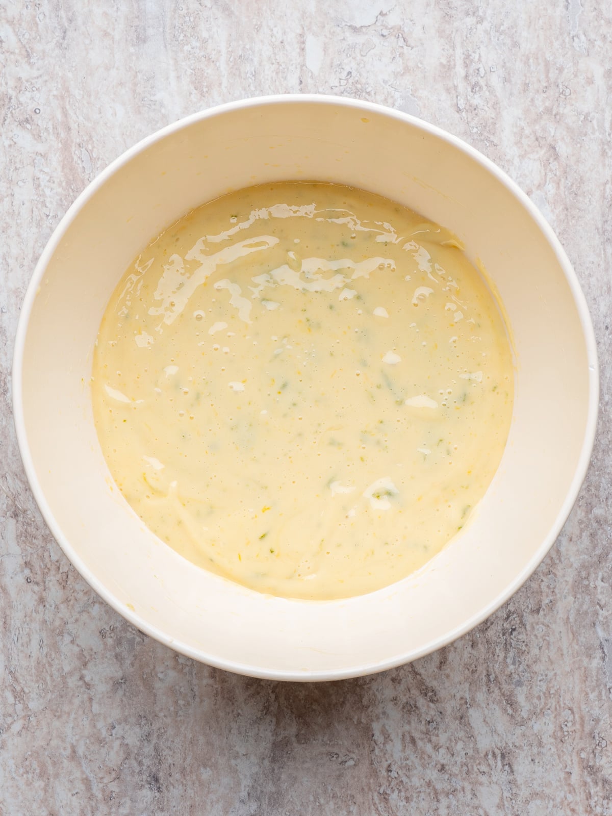 Creamy key lime filling in a mixing bowl, made with lime juice, egg yolks, and sweetened condensed milk.