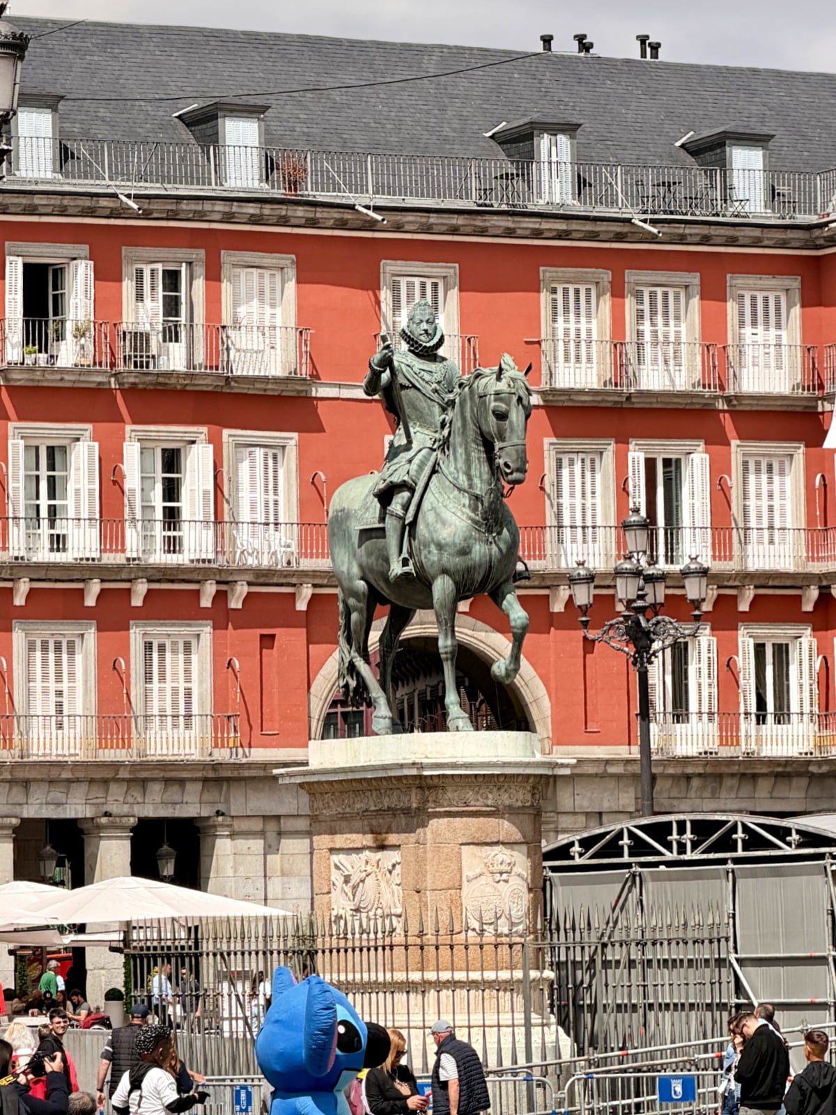 Equestrian statue in Plaza Mayor with Madrid’s iconic red buildings in the background.